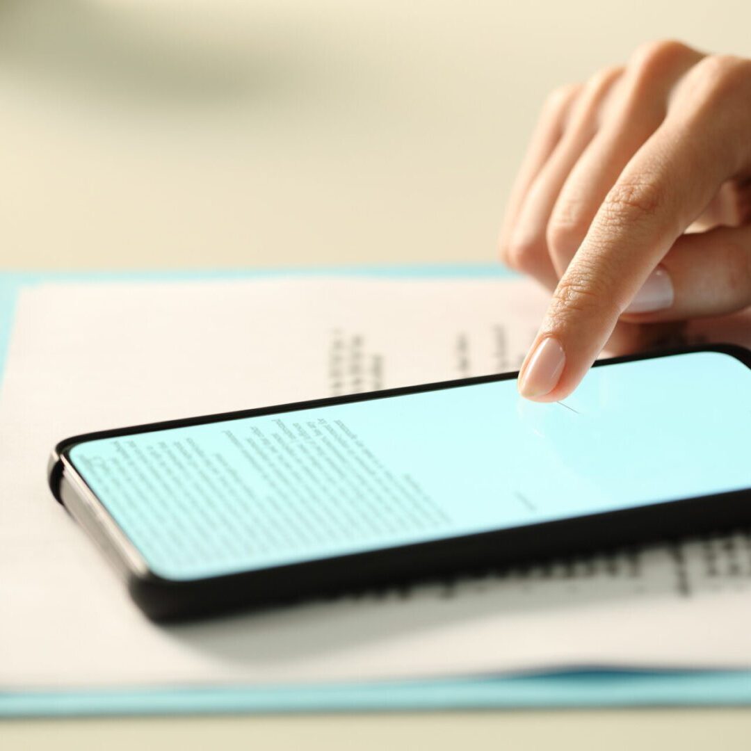 Finger tapping smartphone on a document.